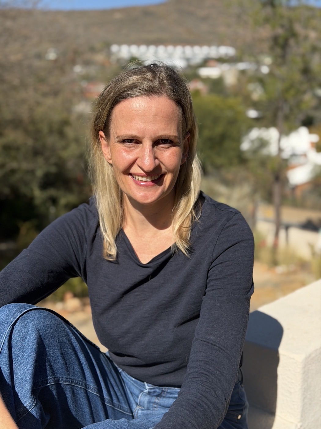 Porträt von Elke Diehl, lächelnd draußen in Namibia